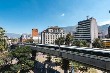 Medellin, Antioquia, Kolombiya. 17 Ocak 2024: Mavi gökyüzü ile Nutibara Oteli ve Medellin metro rayları.