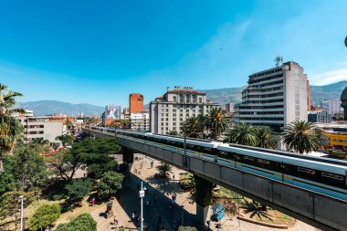 Medellin, Antioquia, Kolombiya. 17 Ocak 2024: Mavi gökyüzü ile Nutibara Oteli ve Medellin metro rayları.