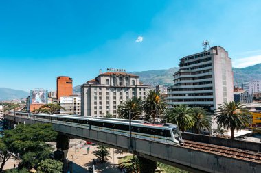Medellin, Antioquia, Kolombiya. 17 Ocak 2024: Mavi gökyüzü ile Nutibara Oteli ve Medellin metro rayları.