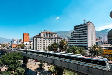 Medellin, Antioquia, Kolombiya. 17 Ocak 2024: Mavi gökyüzü ile Nutibara Oteli ve Medellin metro rayları.
