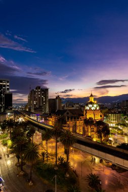 Medellin, Antioquyia, Kolombiya. 17 Ocak 2024: Rafael Uribe Kültür Sarayı ve metro istasyonu güzel renkli gün batımıyla birlikte.