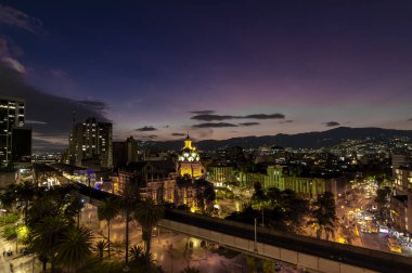 Medellin, Antioquyia, Kolombiya. 17 Ocak 2024: Rafael Uribe Kültür Sarayı ve metro istasyonu güzel renkli gün batımıyla birlikte.