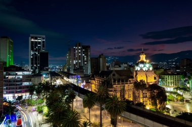 Medellin, Antioquyia, Kolombiya. 17 Ocak 2024: Rafael Uribe Kültür Sarayı ve metro istasyonu güzel renkli gün batımıyla birlikte.