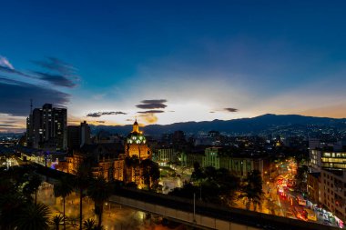 Medellin, Antioquyia, Kolombiya. 17 Ocak 2024: Rafael Uribe Kültür Sarayı ve metro istasyonu güzel renkli gün batımıyla birlikte.