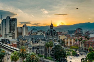 Medellin, Antioquyia, Kolombiya. 17 Ocak 2024: Rafael Uribe Kültür Sarayı ve metro istasyonu güzel renkli gün batımıyla birlikte.