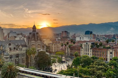 Medellin, Antioquyia, Kolombiya. 17 Ocak 2024: Rafael Uribe Kültür Sarayı ve metro istasyonu güzel renkli gün batımıyla birlikte.