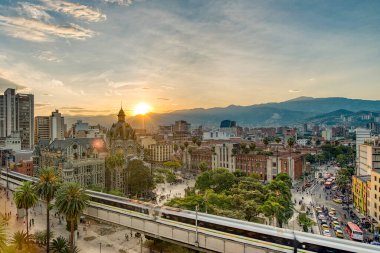 Medellin, Antioquyia, Kolombiya. 17 Ocak 2024: Rafael Uribe Kültür Sarayı ve metro istasyonu güzel renkli gün batımıyla birlikte.