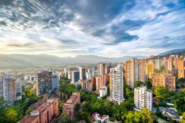 Medelin, Antioquia, Kolombiya. 27 Ağustos 2024: Ufukta güneş ve şehir manzaralı HDR manzarası.