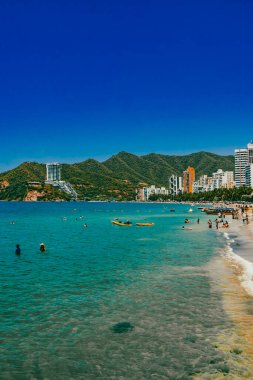 Santa Marta, Magdalena, Kolombiya. 16 Eylül 2024: Deniz manzaralı manzara ve El Roadero plajındaki binalar