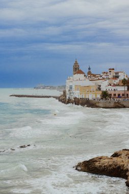 Sitges, Barselona, İspanya. 1 Kasım 2024: San Sebastian sahilindeki eski kasabanın manzarası.