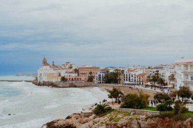Sitges, Barselona, İspanya. 1 Kasım 2024: San Sebastian sahilindeki eski kasabanın manzarası.