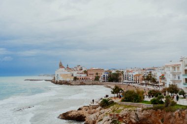 Sitges, Barselona, İspanya. 1 Kasım 2024: San Sebastian sahilindeki eski kasabanın manzarası.