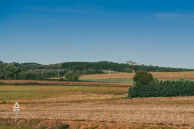 Landscape with view of crops and beautiful mountains with blue sky on the French Way. Stage Portomarin - Palas de Rei. Spain. clipart