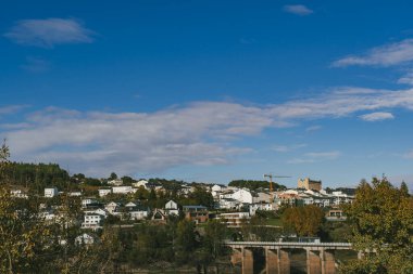 Portomarin ve mavi gökyüzü manzaralı panoramik ve kırsal bir manzara. Portomarin, İspanya.