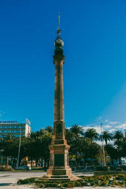La Coruna, İspanya. 11 Kasım 2024: Millennium Obelisk ve mavi gökyüzü saati.