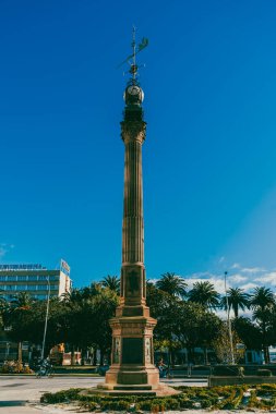 La Coruna, İspanya. 11 Kasım 2024: Millennium Obelisk ve mavi gökyüzü saati.