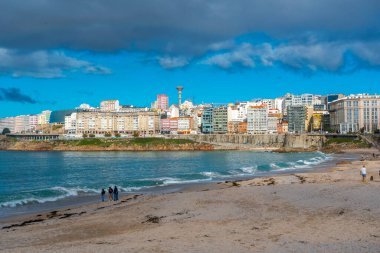 La Coruna, İspanya. 11 Kasım 2024: Mavi gökyüzü ve binalarla Orzn sahilinde manzara.