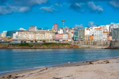 La Coruna, İspanya. 11 Kasım 2024: Mavi gökyüzü ve binalarla Orzn sahilinde manzara.