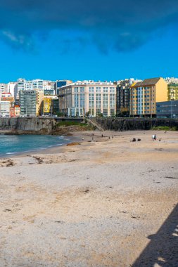 La Coruna, İspanya. 11 Kasım 2024: Mavi gökyüzü ve binalarla Orzn sahilinde manzara.