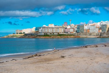 La Coruna, İspanya. 11 Kasım 2024: Mavi gökyüzü ve binalarla Orzn sahilinde manzara.