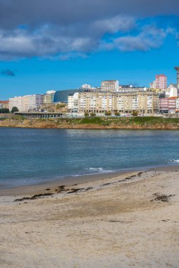 La Coruna, İspanya. 11 Kasım 2024: Mavi gökyüzü ve binalarla Orzn sahilinde manzara.