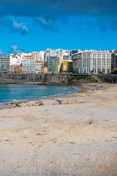 La Coruna, İspanya. 11 Kasım 2024: Mavi gökyüzü ve binalarla Orzn sahilinde manzara.