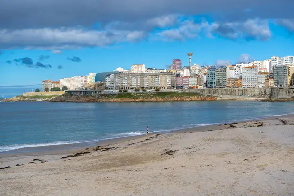 La Coruna, İspanya. 11 Kasım 2024: Mavi gökyüzü ve binalarla Orzn sahilinde manzara.