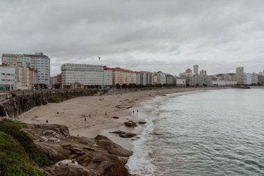 La Coruna, İspanya. 11 Kasım 2024: Orzan sahilinde mavi gökyüzü ve binalar.