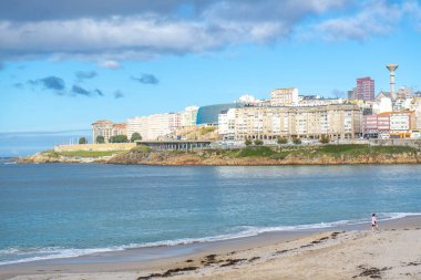 La Coruna, İspanya. 11 Kasım 2024: Orzan sahilinde mavi gökyüzü ve binalar.