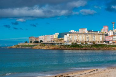 La Coruna, İspanya. 11 Kasım 2024: Orzan sahilinde mavi gökyüzü ve binalar.