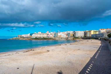 La Coruna, İspanya. 11 Kasım 2024: Orzan sahilinde mavi gökyüzü ve binalar.