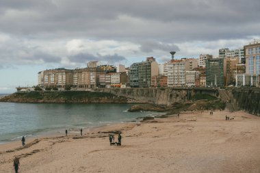 La Coruna, İspanya. 11 Kasım 2024: Orzan sahilinde mavi gökyüzü ve binalar.