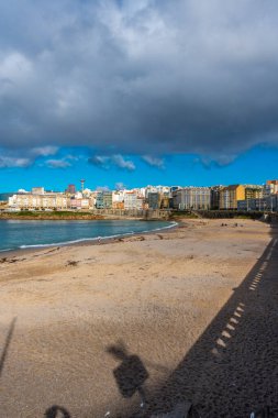 La Coruna, İspanya. 11 Kasım 2024: Orzan sahilinde mavi gökyüzü ve binalar.