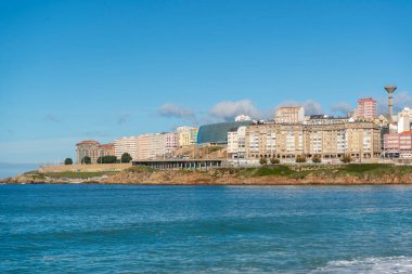 La Coruna, İspanya. 11 Kasım 2024: Orzan sahilinde mavi gökyüzü ve binalar.