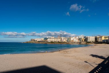 La Coruna, İspanya. 11 Kasım 2024: Orzan sahilinde mavi gökyüzü ve binalar.