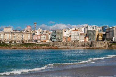 La Coruna, İspanya. 11 Kasım 2024: Orzan sahilinde mavi gökyüzü ve binalar.