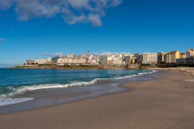 La Coruna, İspanya. 11 Kasım 2024: Orzan sahilinde mavi gökyüzü ve binalar.