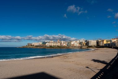 La Coruna, İspanya. 11 Kasım 2024: Orzan sahilinde mavi gökyüzü ve binalar.