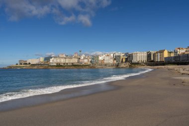 La Coruna, İspanya. 11 Kasım 2024: Orzan sahilinde mavi gökyüzü ve binalar.