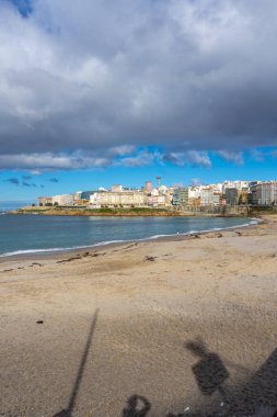 La Coruna, İspanya. 11 Kasım 2024: Orzan sahilinde mavi gökyüzü ve binalar.