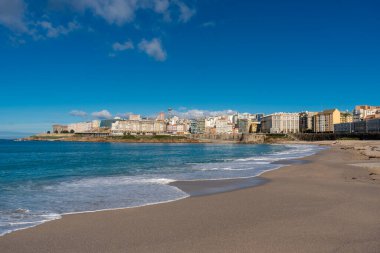 La Coruna, İspanya. 11 Kasım 2024: Orzan sahilinde mavi gökyüzü ve binalar.