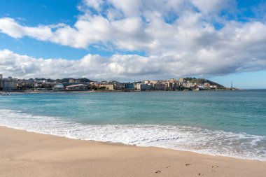 La Coruna, İspanya. 11 Kasım 2024: Orzan sahilinde mavi gökyüzü ve binalar.