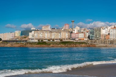 La Coruna, İspanya. 11 Kasım 2024: Orzan sahilinde mavi gökyüzü ve binalar.