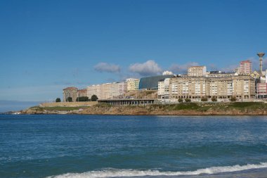 La Coruna, İspanya. 11 Kasım 2024: Orzan sahilinde mavi gökyüzü ve binalar.