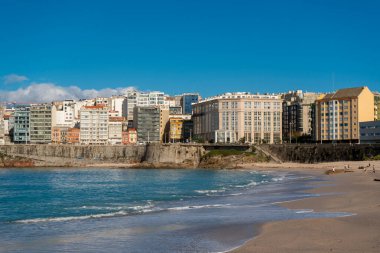 La Coruna, İspanya. 11 Kasım 2024: Orzan sahilinde mavi gökyüzü ve binalar.