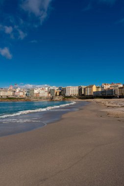 La Coruna, İspanya. 11 Kasım 2024: Orzan sahilinde mavi gökyüzü ve binalar.