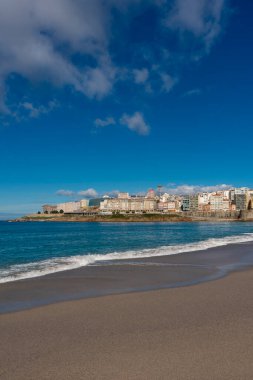 La Coruna, İspanya. 11 Kasım 2024: Orzan sahilinde mavi gökyüzü ve binalar.
