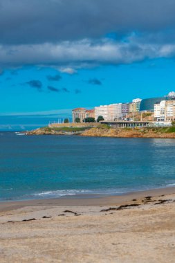 La Coruna, İspanya. 11 Kasım 2024: Orzan sahilinde mavi gökyüzü ve binalar.