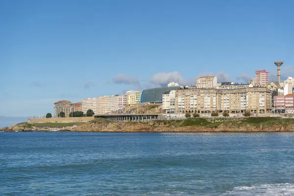 La Coruna, İspanya. 11 Kasım 2024: Orzan sahilinde mavi gökyüzü ve binalar.
