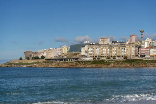 La Coruna, İspanya. 11 Kasım 2024: Orzan sahilinde mavi gökyüzü ve binalar.